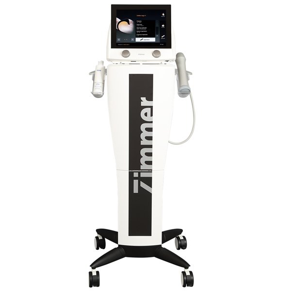 A white Z Wave Q with the word "Zimmer" in large black letters on its front. It features a touchscreen display at the top and two attached handheld applicators. The device is mounted on a wheeled base for mobility.